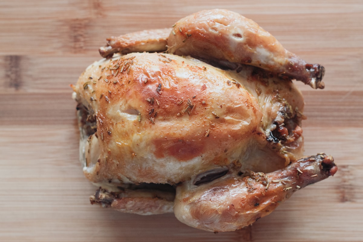 Pollo entero dorándose sobre la parrilla